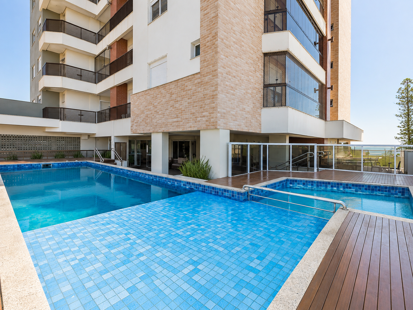 Piscina adulta e infantil aquecidas do condomínio, com deck, raia e vista para o mar