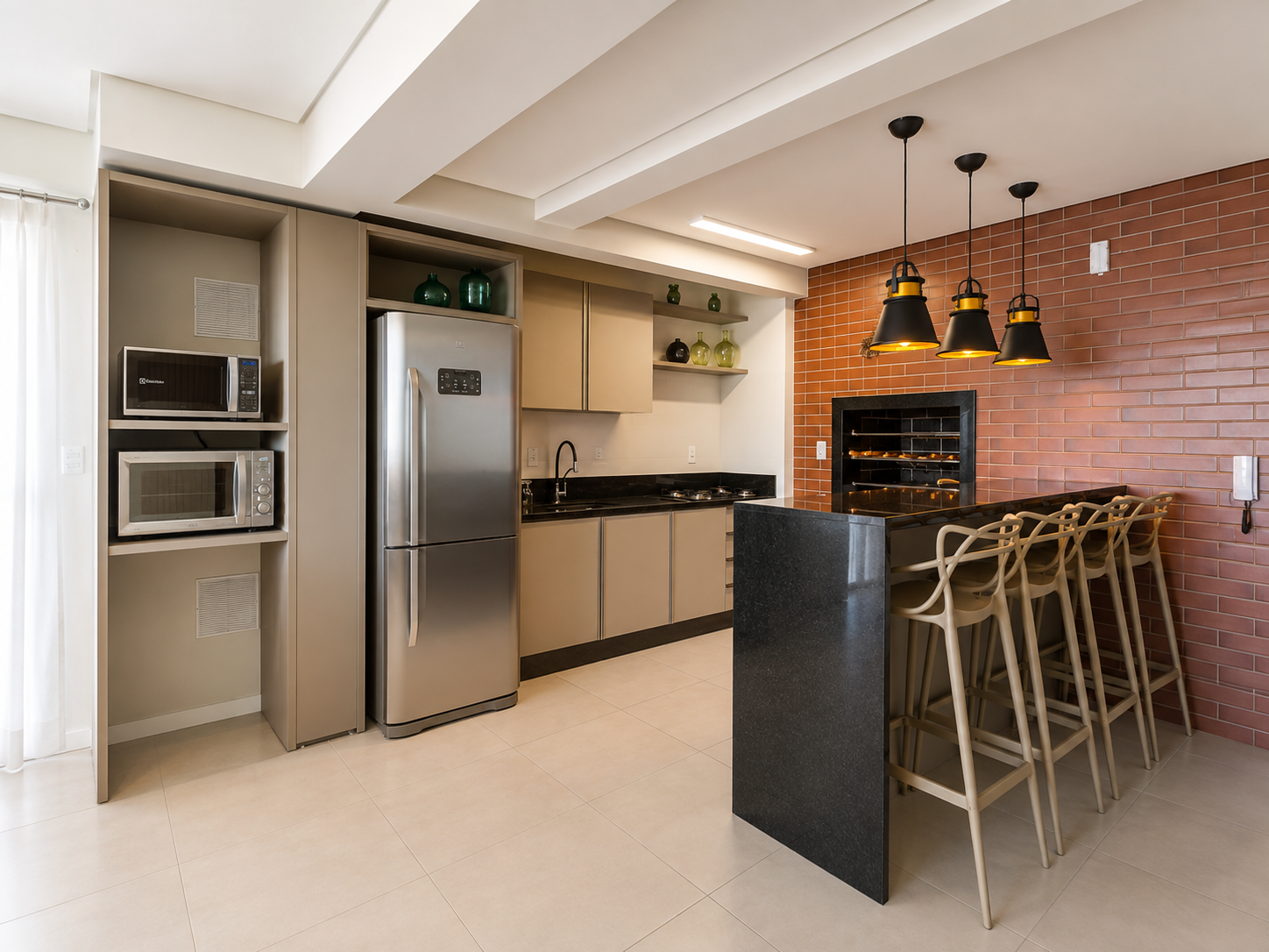 Salão gourmet do apartamento com churrasqueira embutida, bancada em granito, banquetas e ilha