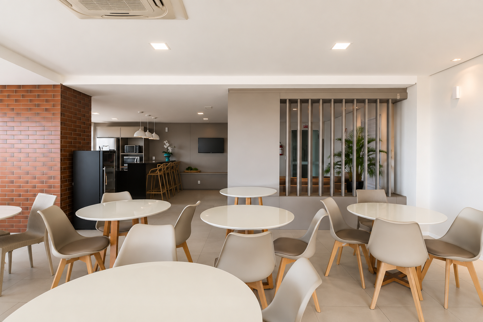 Salão de festas com mesas para receber convidados, cozinha de apoio e detalhe em tijolinho